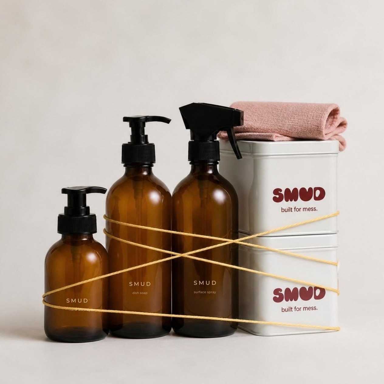 The three amber SMUD bottles and a SMUD tin bundled together with yellow string, a pink cloth on top